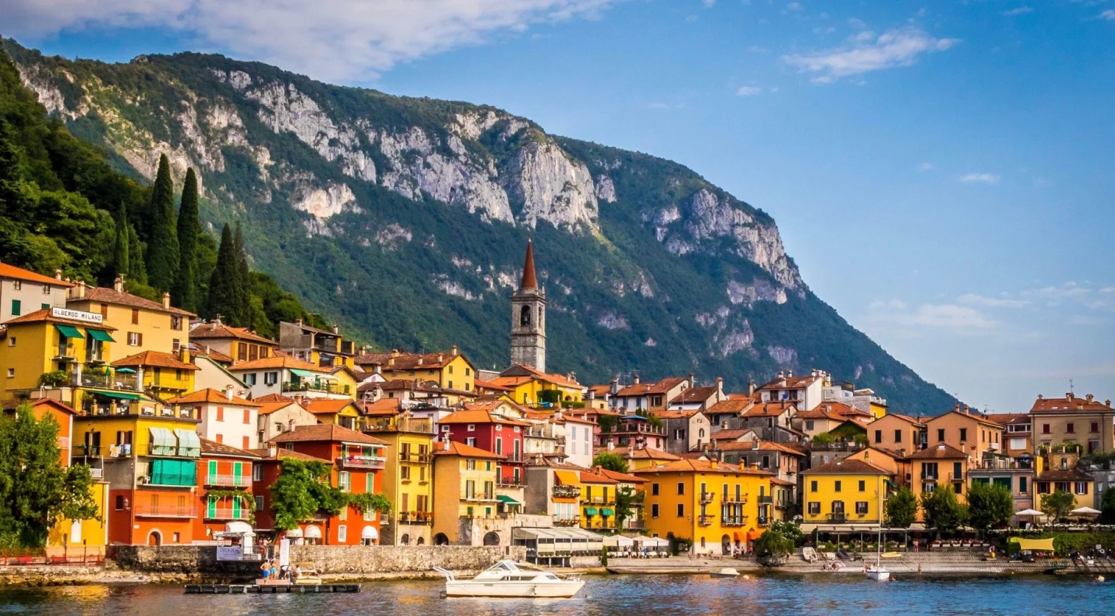 Varenna's colourful houses below a dramatic mountain cliff on Lake Como